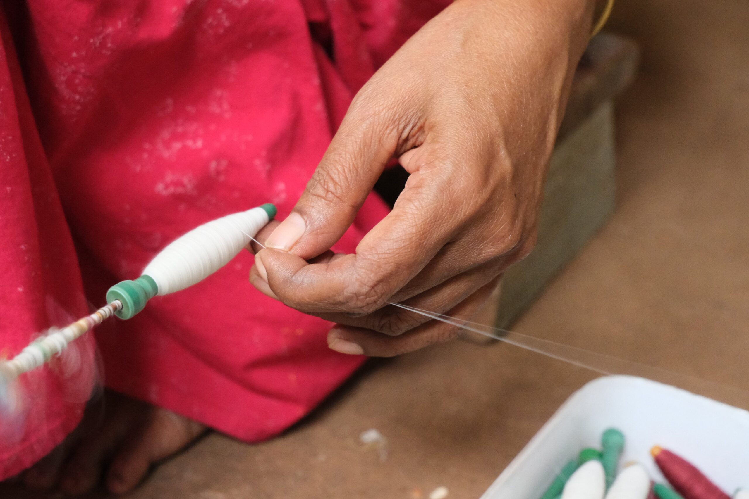 Hands winding cotton yarn onto a bobbin