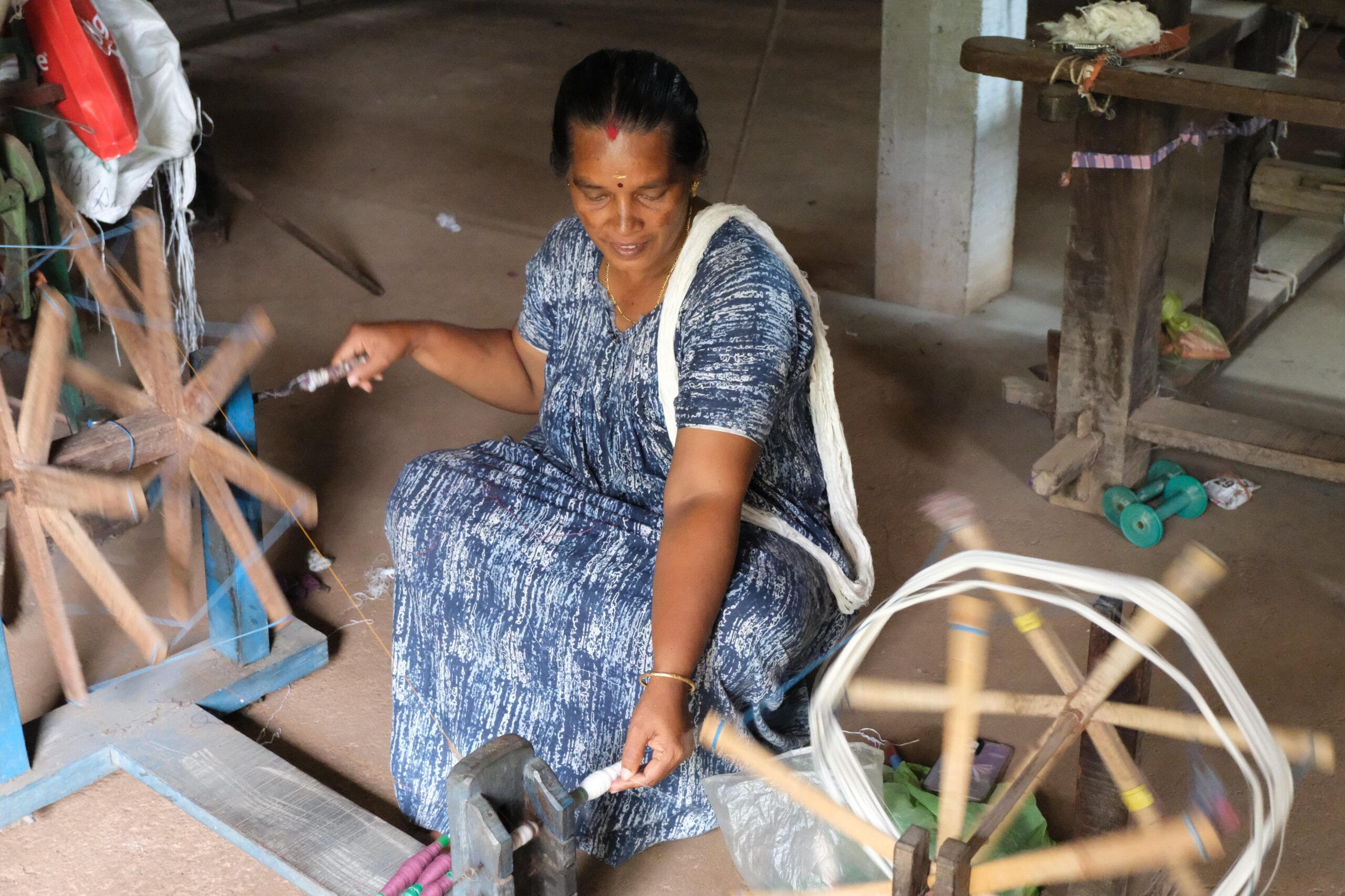 A weaver at the charkha, winding yarn onto bobbins