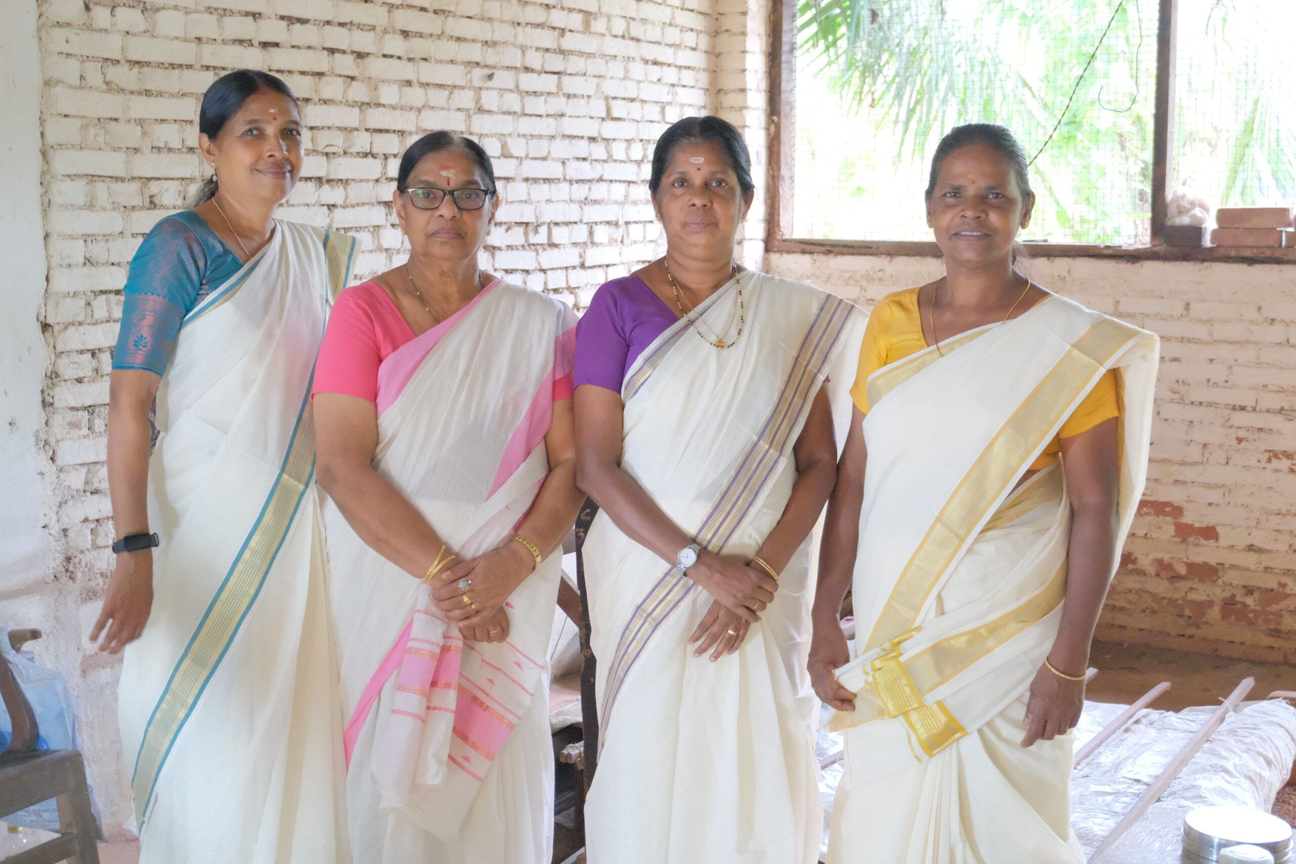Four weavers of Chengamanad standing together in their Kasavu sarees