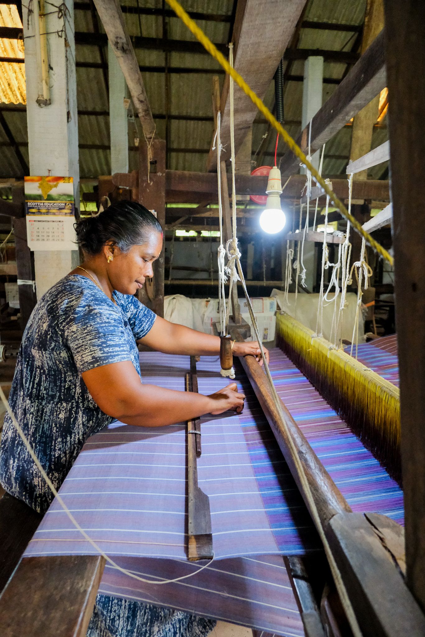 A weaver working at a wooden handloom at Chengamanad