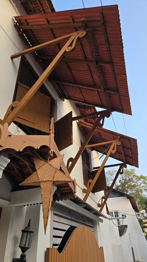 Christmas star lantern under a colonial building’s roof eaves