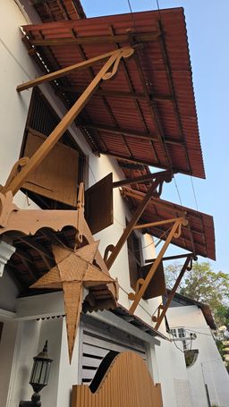 Christmas star lantern under a colonial building’s roof eaves