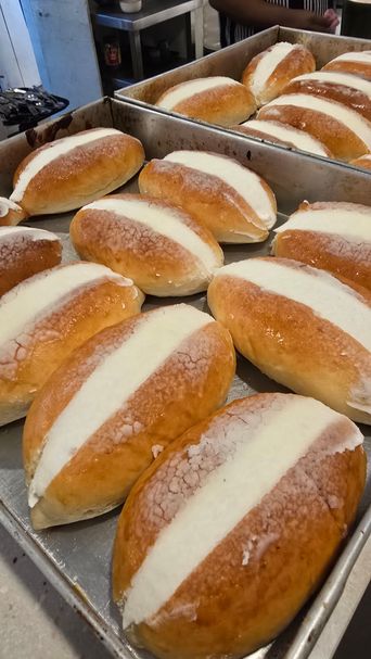 Cream-filled bread rolls on a baking tray