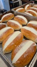 Cream-filled bread rolls on a baking tray