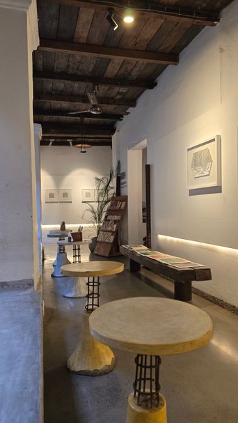 Gallery interior with round concrete stools and framed art on white walls