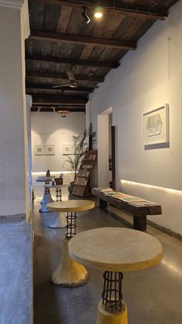 Gallery interior with round concrete stools and framed art on white walls