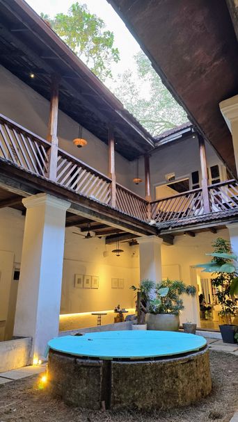 Heritage building courtyard with an upper wooden balcony and blue round table