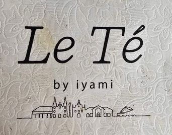 Close-up of a ‘Le Té by iyami’ logo card with a skyline illustration.