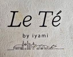 Close-up of a ‘Le Té by iyami’ logo card with a skyline illustration.