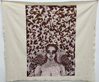 A printed cloth hanging at St. Andrew’s Parish Hall showing a woman’s face flanked by two large birds against a pattern of flying birds.