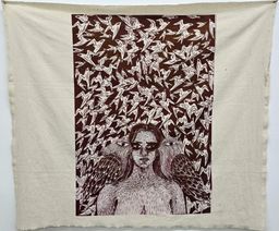A printed cloth hanging at St. Andrew’s Parish Hall showing a woman’s face flanked by two large birds against a pattern of flying birds.