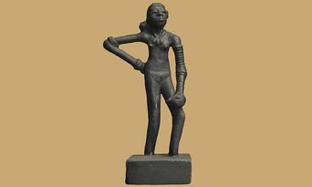 A small dark bronze figurine of a standing nude woman with a segmented, coiled left arm, photographed against a plain tan background.