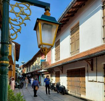 Street lamp with a Star of David ornament over a lane of white shuttered buildings in Jew Town