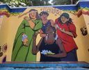 A wall mural on Poovath Street titled ‘Fearless’, showing four women adorned with flowers and bangles under a rainbow-scalloped border.
