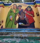 A wall mural on Poovath Street titled ‘Fearless’, showing four women adorned with flowers and bangles under a rainbow-scalloped border.