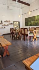 Cafe interior with wooden cross-frame tables, chairs and hanging lanterns