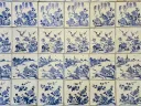 Rows of blue-and-white Chinese porcelain tiles, each hand-painted with a different floral or landscape scene, covering the synagogue floor.