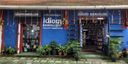 Blue shopfront with ‘Idiom Booksellers’ signage and potted plants outside.