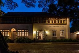 Front of the Old Harbour Hotel at night: a pale two-storey building with its name on the wall and a lit arched doorway, across a cobbled street.