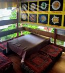 Low table with red patterned floor cushions under a photo-menu banner listing momo dishes