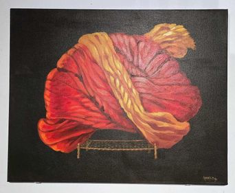 A painting on a black ground of a huge coiled turban in red, orange and gold, resting on a small woven rope cot.